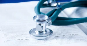 Stethoskop liegt auf einem medizinischen Fachbuch über Endokrinologie – Symbol für fachliche Tiefe in der 1:1 Intensivpflege.