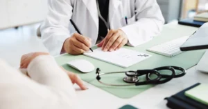 Ärztin bespricht mit einer Patientin Unterlagen zur Versorgung bei Pflegegrad 5.