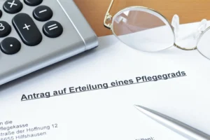 Pflegegrad beantragen ohne häufige Fehler: Ein ausgefülltes Pflegetagebuch liegt geordnet auf einem Tisch neben einer Brille und einem Taschenrechner.